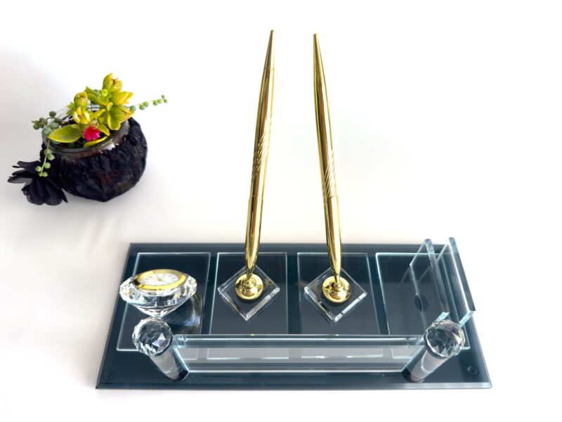 il_fullxfull.6139827113_8ou8.jpg Make the ultimate executive statement with our Executive Name Plates with Double Pen collection. Designed for senior leaders, partners, and business owners who operate at the highest levels of professional authority, these sets are more than simple identifiers—they are comprehensive desktop command centers. Each piece is architectural in its design, crafted from 100% high-density crystal glass to provide a heavy, high-end feel that signifies stability and permanent success. This premium collection features two integrated professional-grade signature pens (available in gold or silver tones), ensuring you are always prepared for high-stakes contract signings or joint approvals. The interplay between the hand-polished glass facets and the dual metallic pen holders creates a brilliant sparkle that reflects your career achievements. Our advanced metal sublimation technology on the 1.77 x 5.90-inch plate ensures your name, executive title, and corporate logo are displayed with absolute clarity and vibrant detail that will never fade. By choosing our Executive Name Plates with Double Pen, you are investing in an artisan-crafted material that carries a professional 'heft' that plastic or acrylic simply cannot replicate. Arriving in our signature red kraft gift box, these dual-pen crystal sets are the definitive choice for executive promotions, corporate anniversaries, and prestigious legal or medical offices.